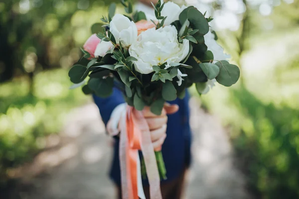 Noivo detém um buquê de casamento — Fotografia de Stock