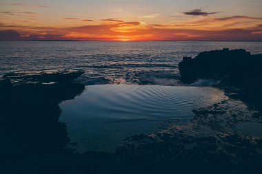 Okyanusa bir uçurumun üzerinden gün batımı görünümü