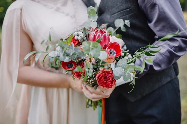 ช่อดอกไม้แต่งงานในมือของคู่รัก ภาพสต็อก