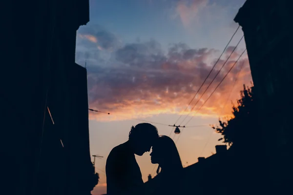 저녁 하늘 그리고 도시에 대 한 사랑 하는 커플의 실루엣 — 스톡 사진