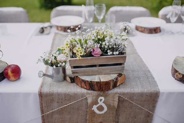 木製の浴槽とテーブルを結婚式、お祝いテーブルに金属製じょうろの野生の花 — ストック写真