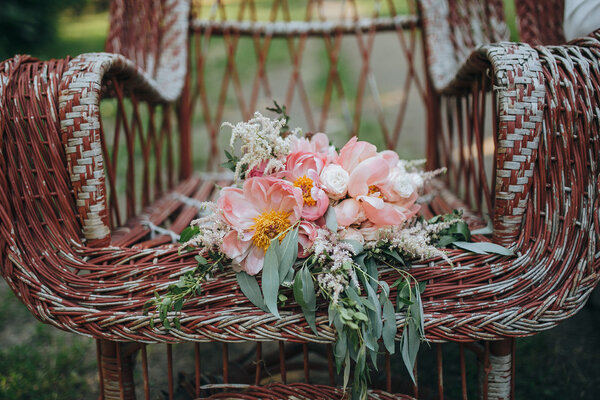 Bouquet of pink and white peonies and green is in a vintage garden chairs on the background of green garden Royalty Free Stock Photos