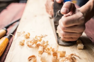 Man working with hand jack plane, close up photo