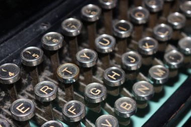 Eski makine kirli, ağır, mekanik harf işaretleri yazar.