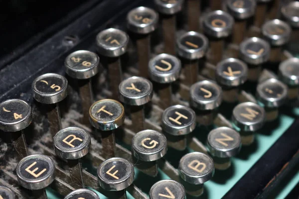 Eski makine kirli, ağır, mekanik harf işaretleri yazar.