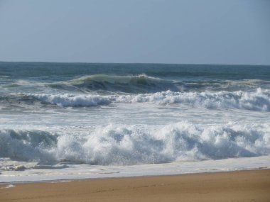 Güzel bir sahil, deniz ve sıcak dalgaları, güneş, gökyüzü, tuzlu hava.
