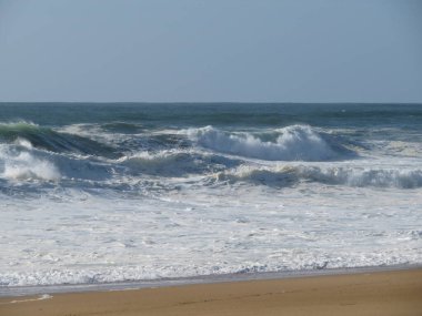Güzel bir sahil, deniz ve sıcak dalgaları, güneş, gökyüzü, tuzlu hava.