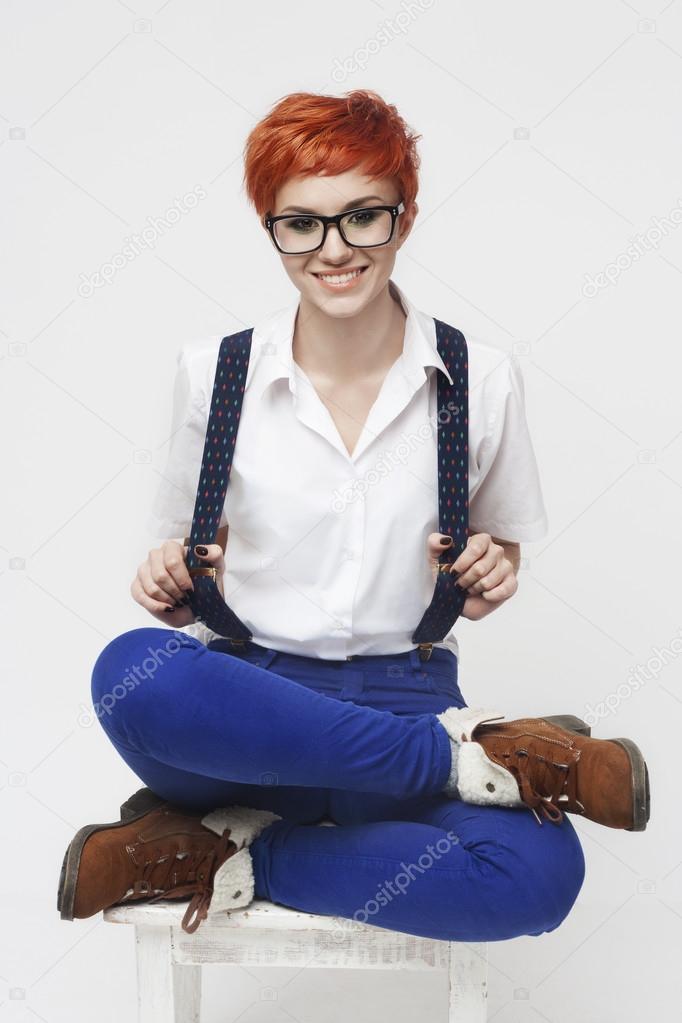 Funny portrait of a girl with red hair and a cross-legge.
