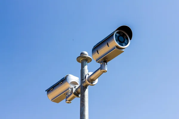 Cámara de seguridad sobre fondo azul cielo — Foto de Stock