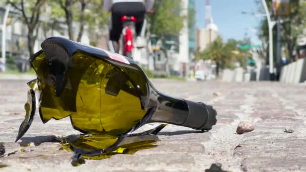 Närbild Trasiga Alkohol Flaska Gatan Med Cyklist Ryggen — Stockvideo