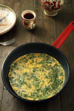 Omellet metal tavada otlar ile
