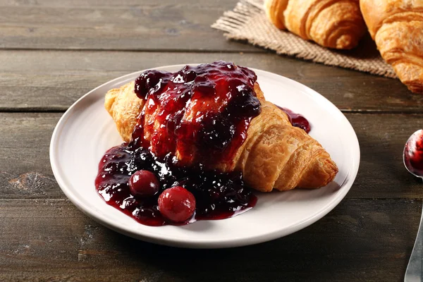 Croissant on rustic kitchen table — Stock Photo, Image