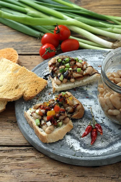 Boiled white beans on toasted bread — Stock Photo, Image