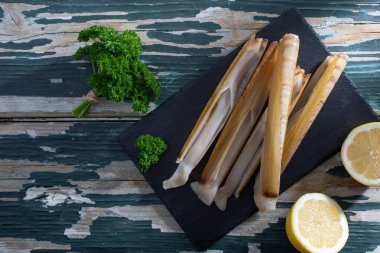 Yeşil masa arkasında çiğ deniz ürünleri