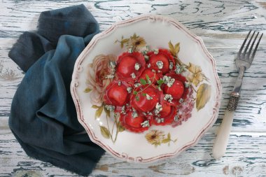 salad with tomato, cheese and basil on a white plate