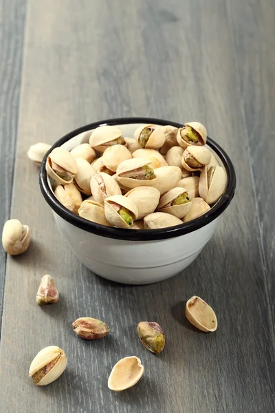 Salted pistachios in metal bow — Stock Photo, Image