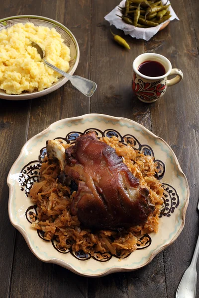 Vista superior de cerdo asado con repollo sobre mesa rústica —  Fotos de Stock