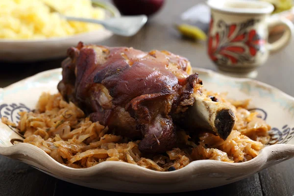 Жареная свинина с капустой на деревенском столе — стоковое фото