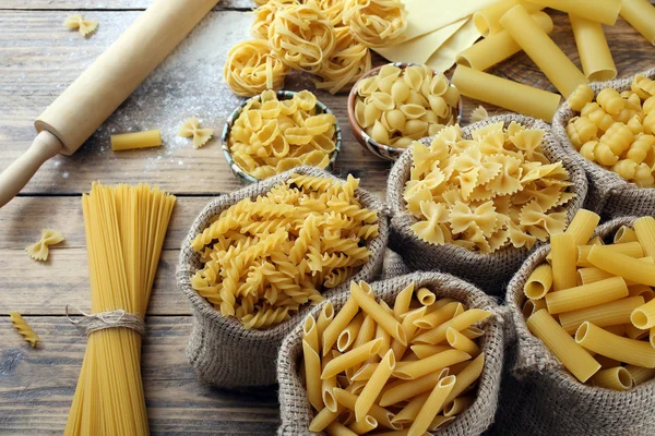 Top view raw italian pasta on rustic table — Stock Photo, Image