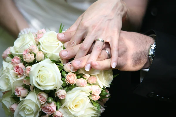 Le mani di coppia nuziale su mazzo rosa — Foto Stock