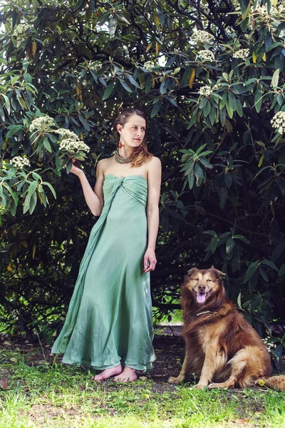 Young beautiful woman in elegant green dress and her dog — Stock Photo, Image