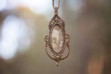 Bulanık orman arka planında mineral mücevher süsleme kolyesi