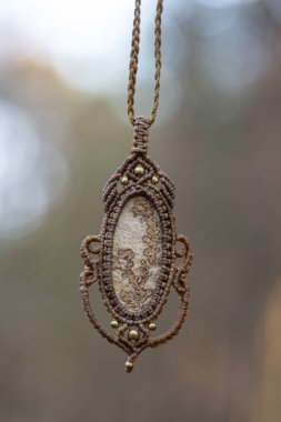 Bulanık orman arka planında mineral mücevher süsleme kolyesi