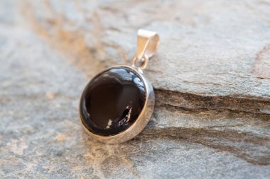 Kayalık arka planda mineral akik değerli taşlı saf gümüş kolye.