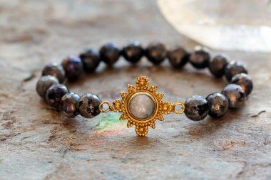 Tarafsız arkaplanda ay taşı ve labradorit taş bilezik