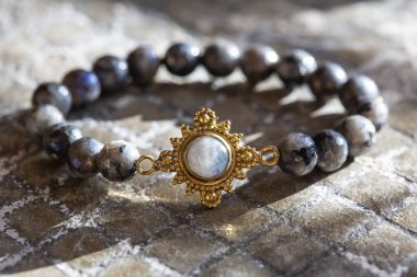 Tarafsız arkaplanda ay taşı ve labradorit taş bilezik