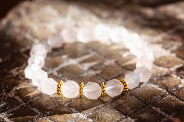 Doğal gri arkaplana yerleştirilmiş mineral değerli taş bilezik.