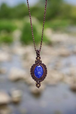 Boho tarzında güzel bir kolye. Lapis lazuli mineral taşı ve doğal bulanık arkaplan.