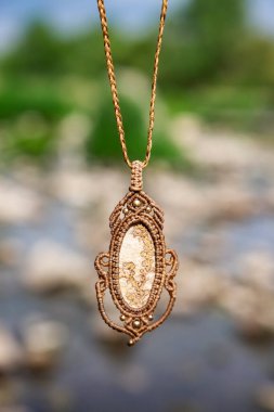 Boho tarzında güzel bir kolye, doğal bulanık arkaplan üzerinde mineral taşı var.
