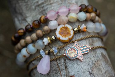 Tahta çubuk üzerinde mineral taş bilezik koleksiyonu.