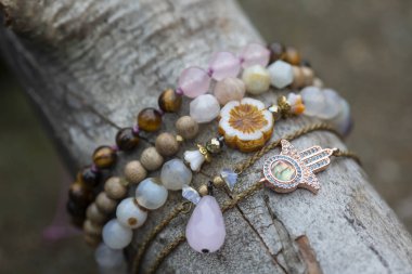 Tahta çubuk üzerinde mineral taş bilezik koleksiyonu.