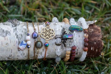 Tahta çubuk üzerinde mineral taş bilezik koleksiyonu.