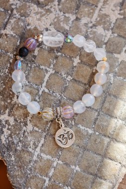 Gümüş kolye Sanskritçe om mineral boncuklar doğal kayalık zemin üzerinde bilezik