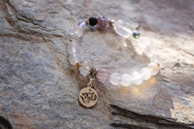 Gümüş kolye Sanskritçe om mineral boncuklar doğal kayalık zemin üzerinde bilezik