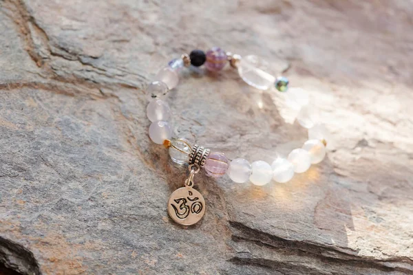 Gümüş kolye Sanskritçe om mineral boncuklar doğal kayalık zemin üzerinde bilezik