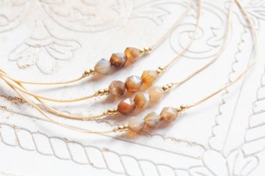 Beyaz arka planda mineral taşı boncuk iplik mücevher bileziği aktar