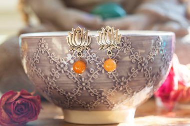 Dekoratif arka planda asılı mineral taşından boncuklu nilüfer küpeler.