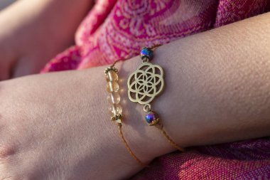 Yaşam tohumu pirinç kolye bilezik ve kadın elinde mineral boncuklar bilezik.