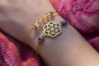 Yaşam tohumu pirinç kolye bilezik ve kadın elinde mineral boncuklar bilezik.