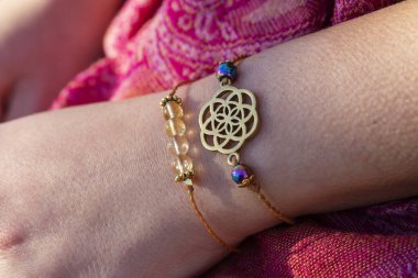 Yaşam tohumu pirinç kolye bilezik ve kadın elinde mineral boncuklar bilezik.