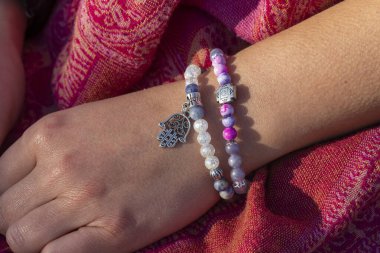 Mineral taşından bilezikler takan bir kadın. 