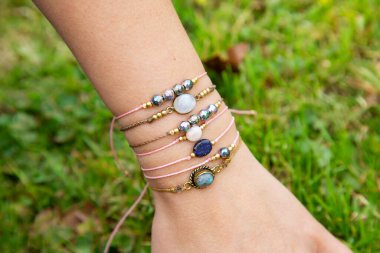 Kadın eli küçük değerli bilezik koleksiyonu takıyor.