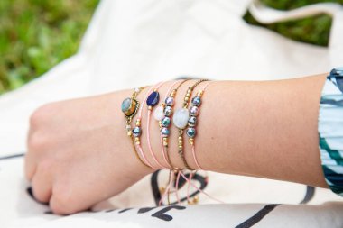 Kadın eli küçük değerli bilezik koleksiyonu takıyor.