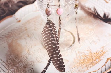 Romantik arkaplanda tüy ve pembe opal taşı küpeler