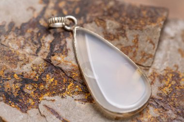 Kayalık zeminde gümüş metal mineral taş kolye