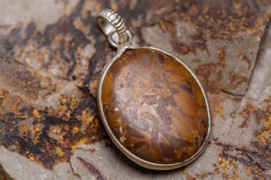 Kayalık zeminde gümüş metal mineral taş kolye